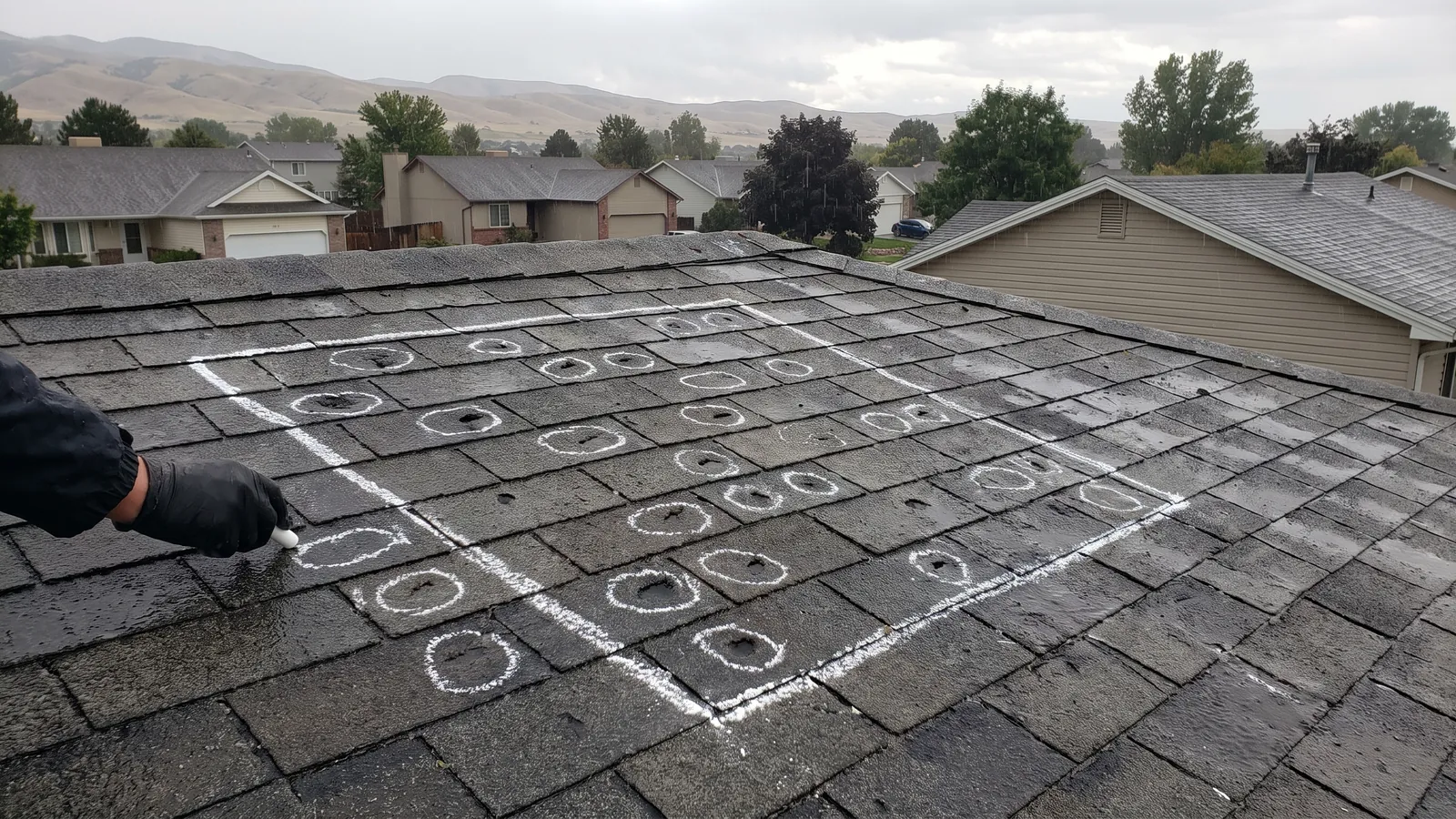 Chalk circles marking hail bruises inside a test square on an asphalt shingle roof in the Treasure Valley